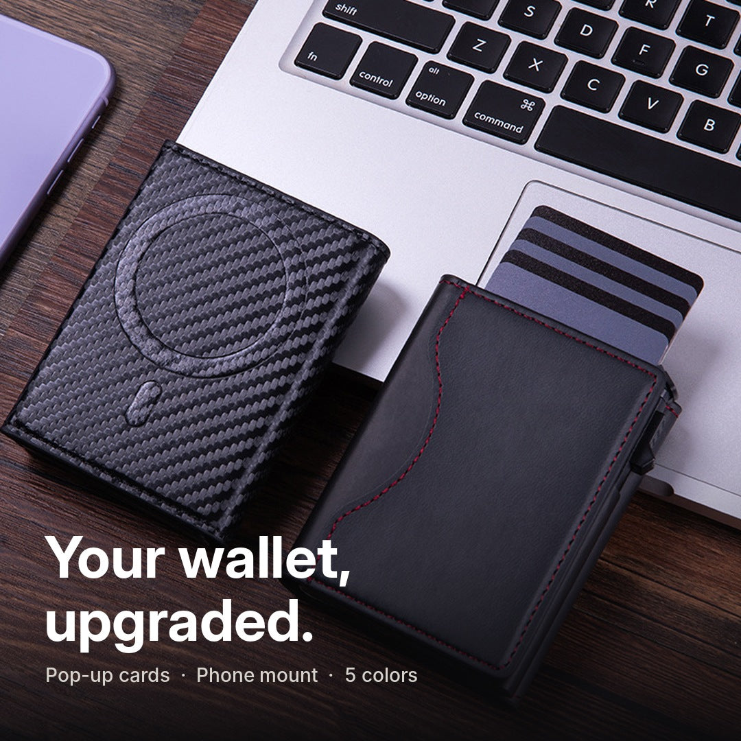 Carbon and black wallets on a desk next to a laptop